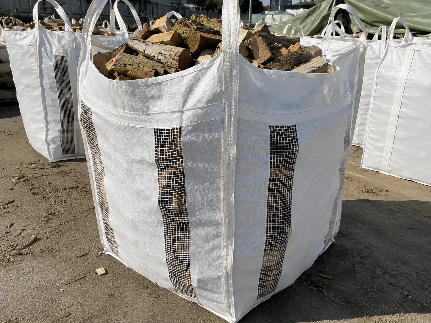 Ventilated FIBC bulk bag with breathable fabric strips filled with firewood